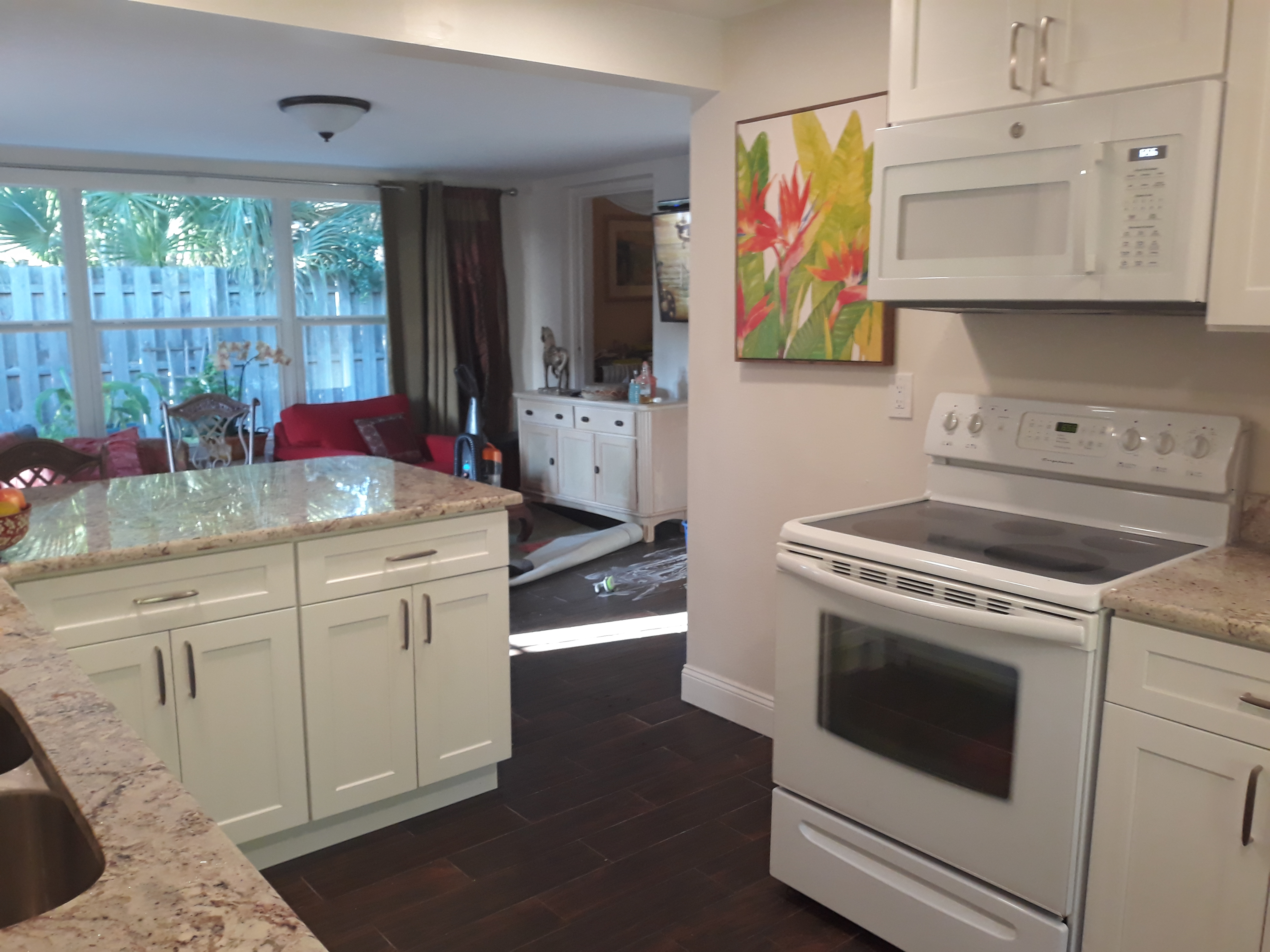 The kitchen opens out to the livingroom with a dining counter and chairs. The glass top stove has a full oven and a microwave above the range.